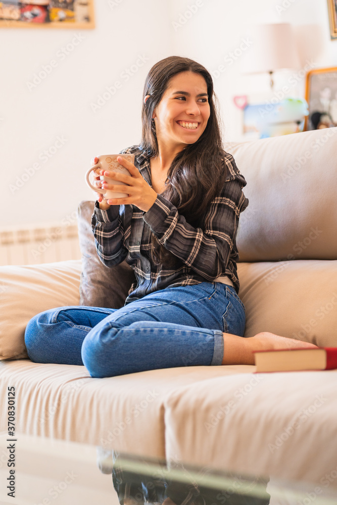 Young woman with cup of coffee resting on sofa Young woman with cup of coffee resting on sofa