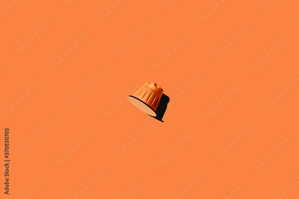 Top view of orange coffee pod placed on orange background Top view of orange coffee pod placed on orange background