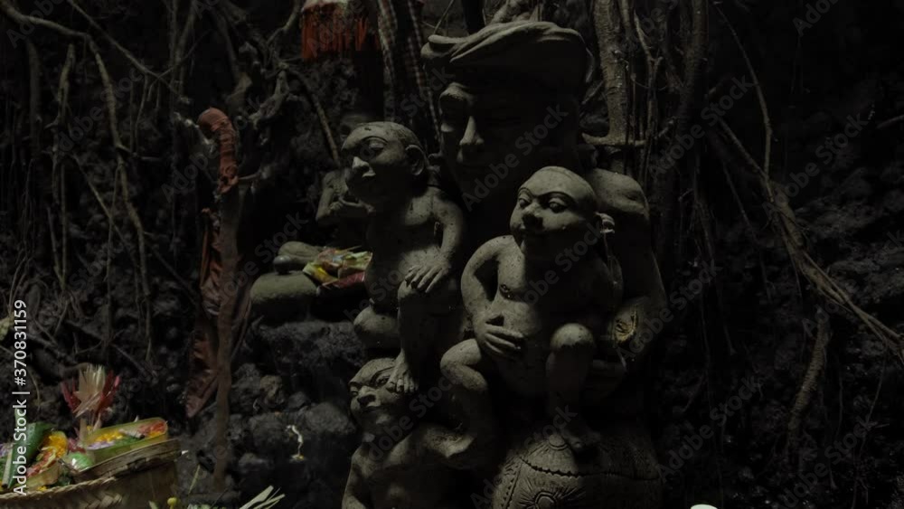 Religious place for rites with ancient statues of people in a dark cave with strong shadows Religious place for rites with ancient statues of people in a dark cave with strong shadows