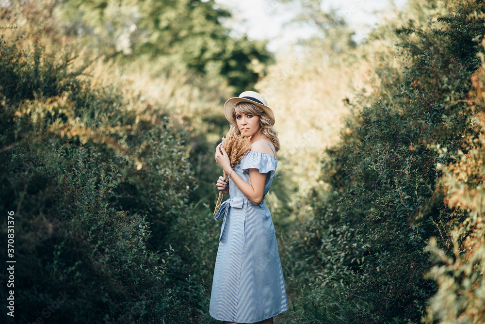 girl with a hat and ears of corn in her hands