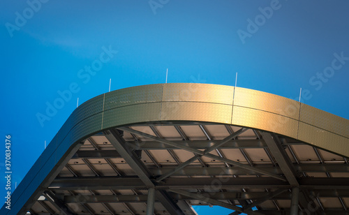 From below fragment of modern building with metal elements and curved lines against cloudless blue sky in New York City photo