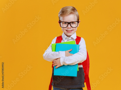 Excited schoolboy with textbooks smiling