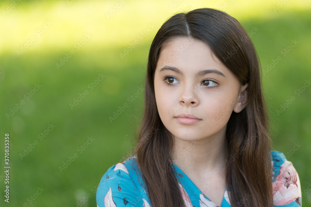 Little girl with long hair relaxing in park sunny day green grass background, international childrens day concept Little girl with long hair relaxing in park sunny day green grass background, international childrens day concept