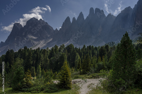 On trekking trail to Malga Brogles refuge with the view of Puez-Odle mountain group needle-shaped peaks ahead, Puez-Odle Nature park, Dolomites, South Tirol, Italy.