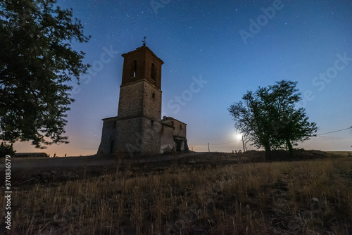 Low view of bell tower on the hill under spectacular scenery with starry night sky photo