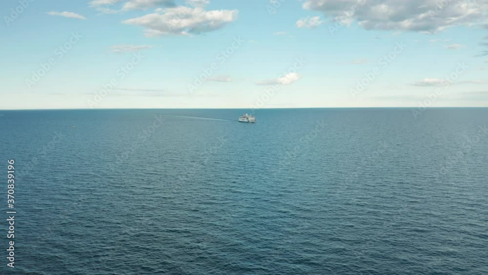 Cruise ship in the open ocean, aerial view of ship in distance Cruise ship in the open ocean, aerial view of ship in distance