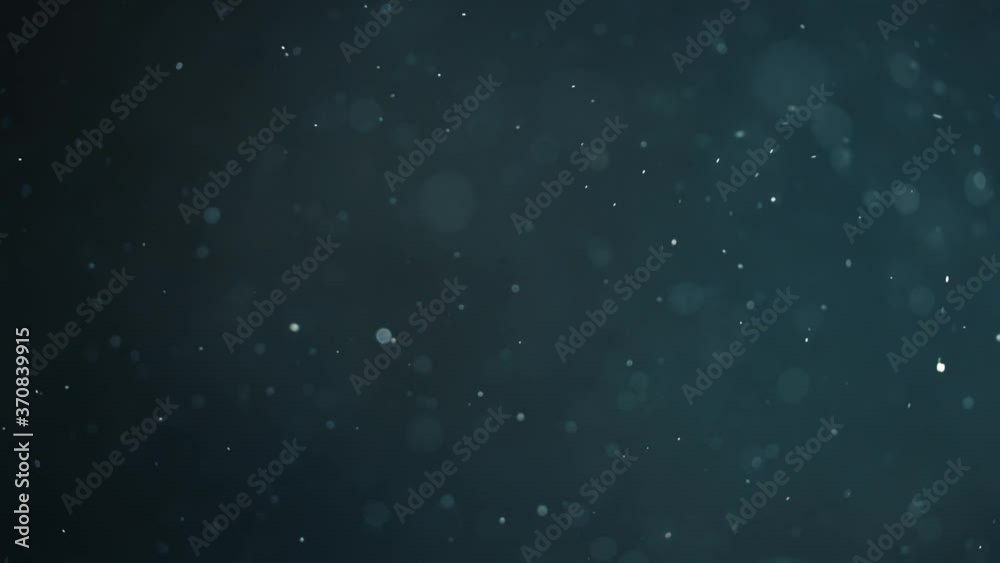 Floating abstract particle bokeh on dark background
