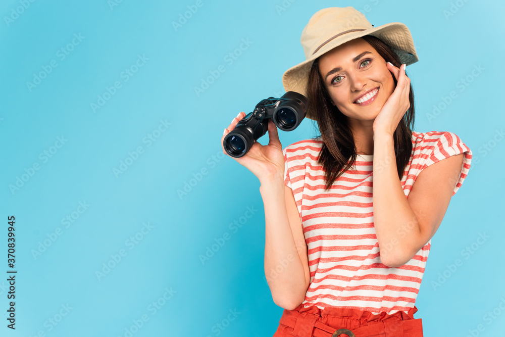 happy woman in hat holding binoculars on blue happy woman in hat holding binoculars on blue