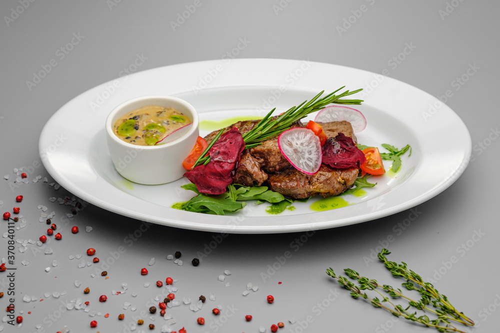 Grilled maso with vegetables and rosemary on a white plate. Grilled maso with vegetables and rosemary on a white plate.