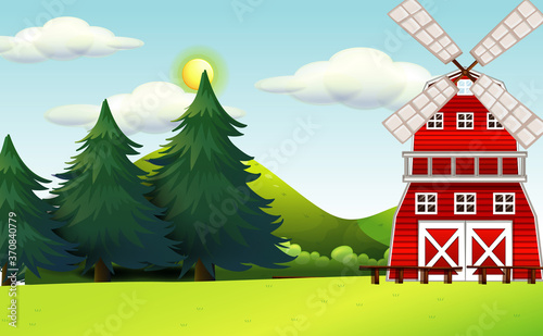 Farm in nature scene with windmill and big pines