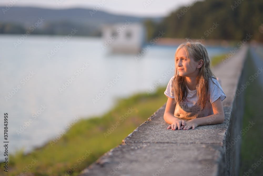 Happy young girl on the sunset in nature in summer 