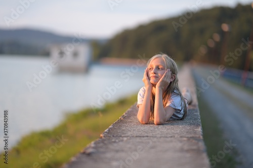 Happy young girl on the sunset in nature in summer 