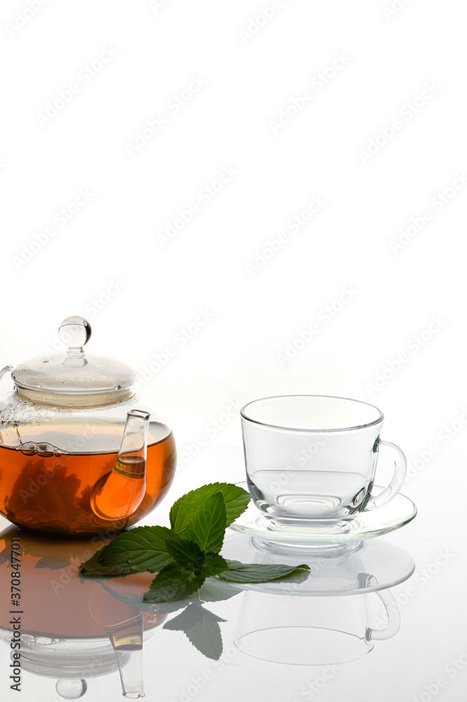 A Cup of tea with a mint branch on a white background. A Cup of tea with a mint branch on a white background.