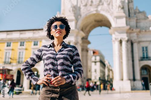 Woman wearing sunglasses standing against Praco Do Comercio in Lisbon, Portugal