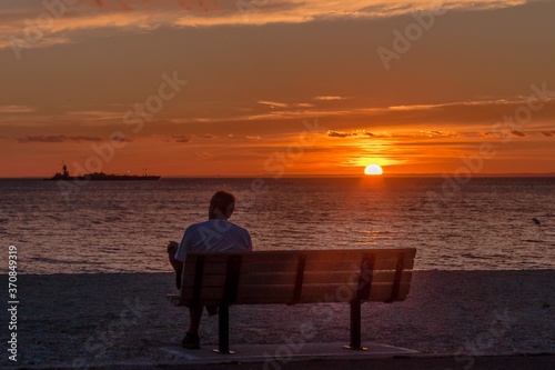 a single man on the beach at sunset, missing his soul mate. © Jay