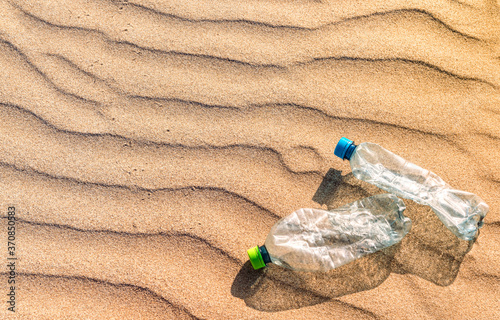 Plastic bottles lying on rippled beach sand