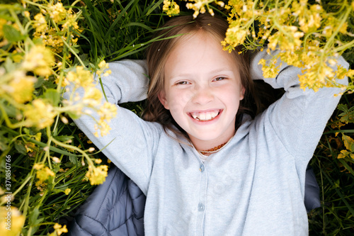 Smiling girl lying in rape flowers