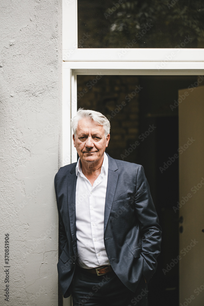 Senior businessman leaning in open office door Senior businessman leaning in open office door