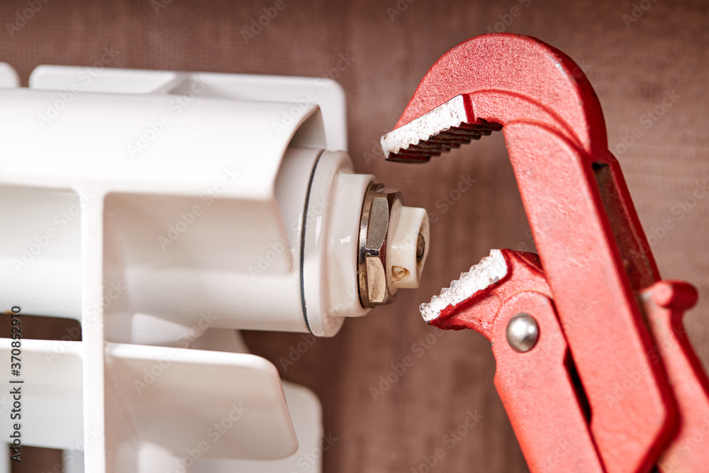 male technician worker repairing aluminum water radiator indoors. plumber repairman concept. water heating system diagnose male technician worker repairing aluminum water radiator indoors. plumber repairman concept. water heating system diagnose