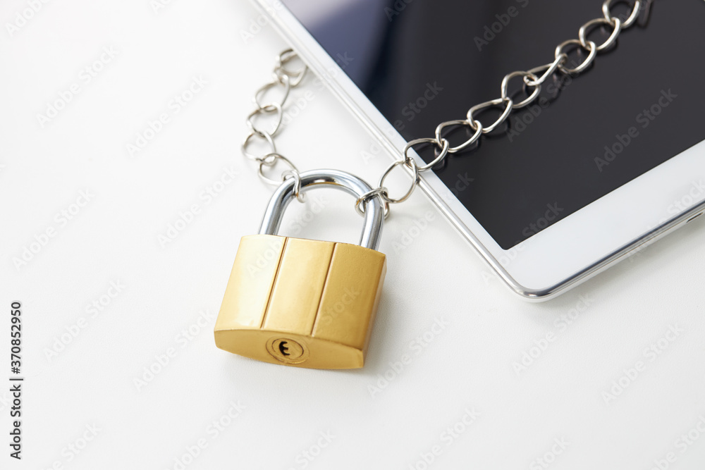 tablet with padlock near it over white background. digital data security concept. virus protection software concept tablet with padlock near it over white background. digital data security concept. virus protection software concept
