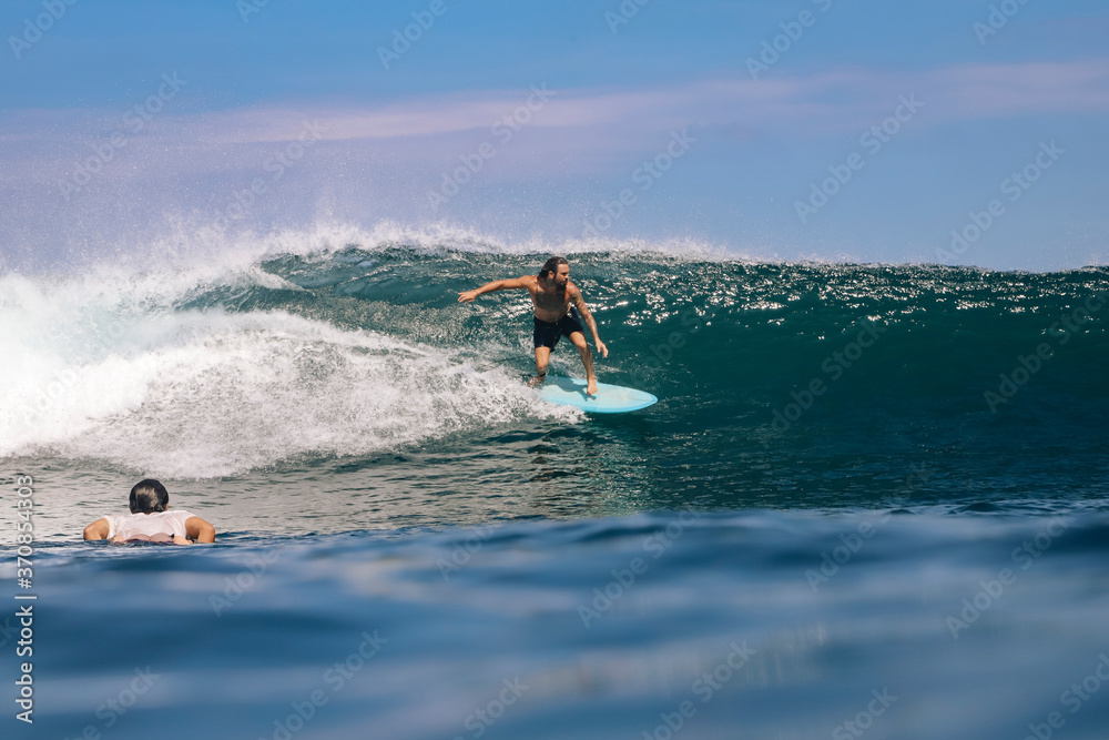 Shirtless man surfing on sea against sky, Bali, Indonesia Shirtless man surfing on sea against sky, Bali, Indonesia