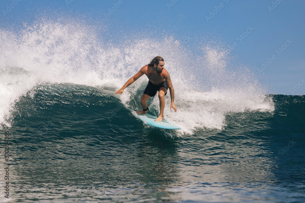 Shirtless man surfing on sea against clear sky, Bali, Indonesia Shirtless man surfing on sea against clear sky, Bali, Indonesia