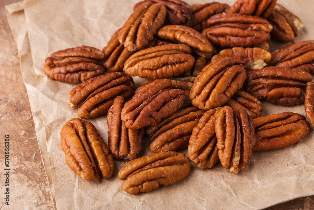 Pecans on paper, brown background,, full size Pecans on paper, brown background,, full size