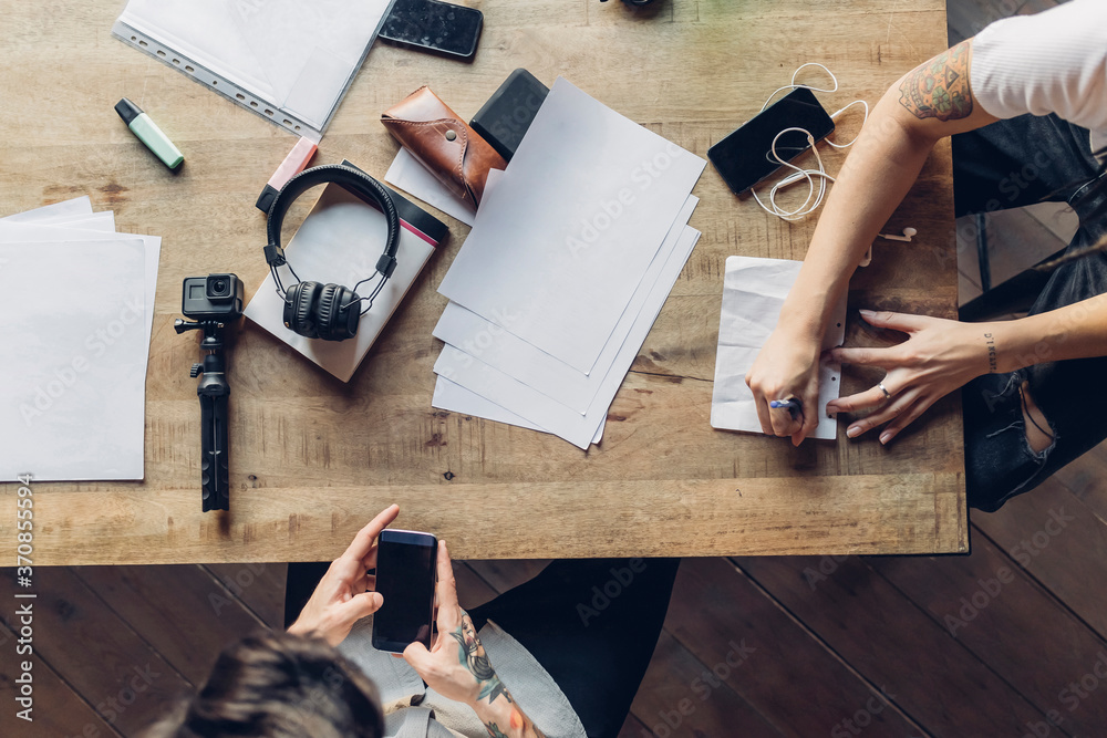 © Westend61 - Two creative business people working at wooden table