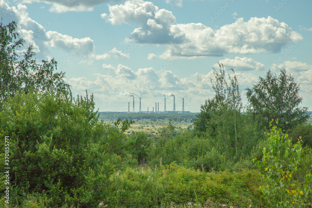 green fields with trees on the background of a processing plant
