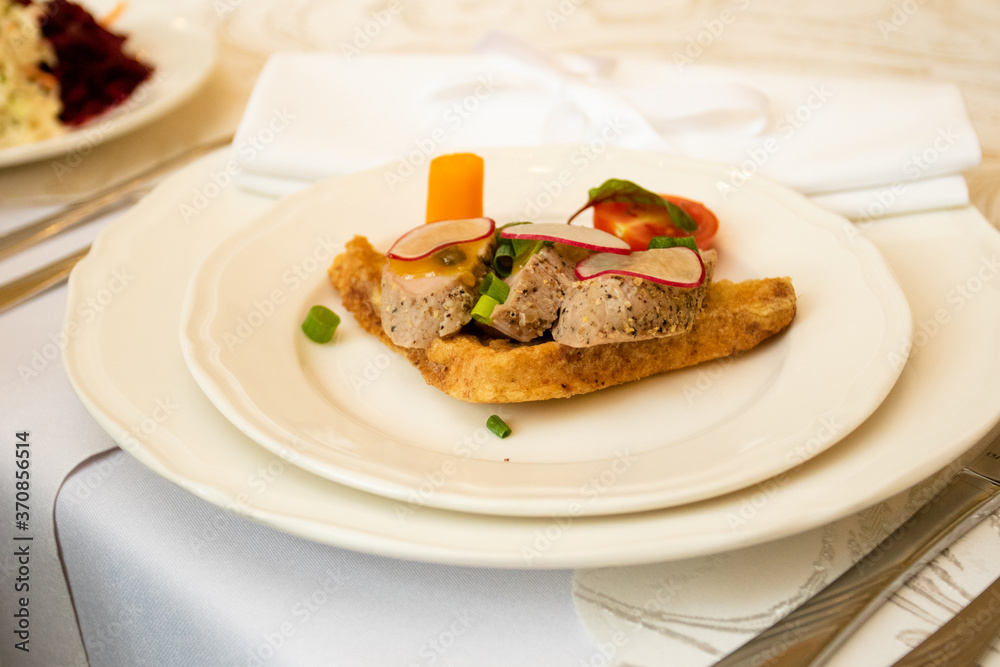 A healthy dish with meat and vegetables. Healthy food in a restaurant. Table setting with white plates A healthy dish with meat and vegetables. Healthy food in a restaurant. Table setting with white plates