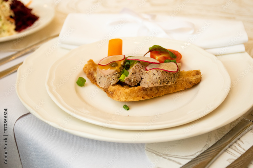 A healthy dish with meat and vegetables. Healthy food in a restaurant. Table setting with white plates