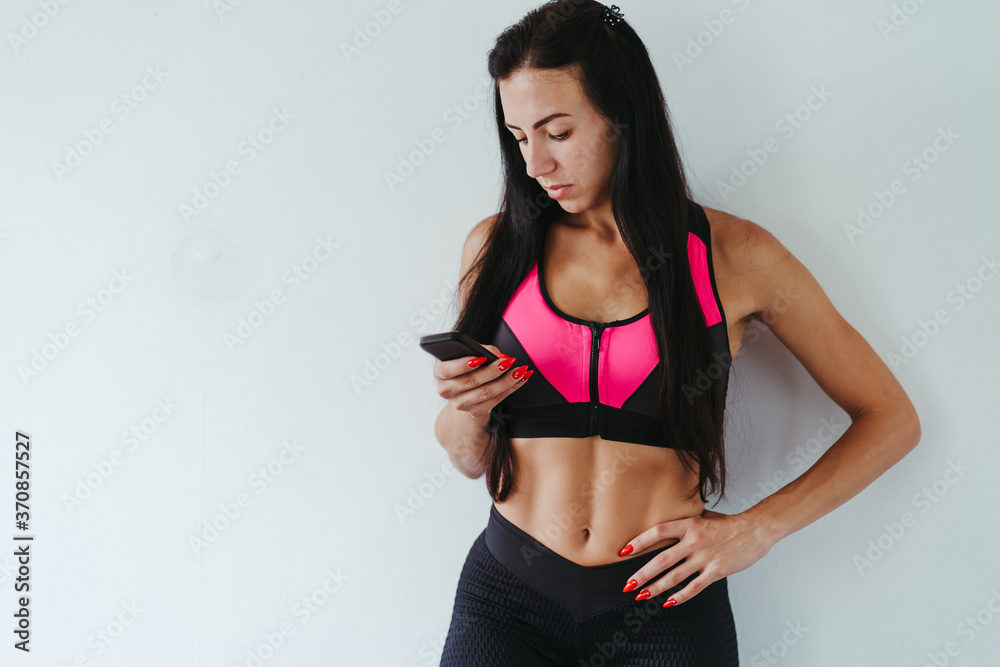 Obraz premium Fitness app, sport gadget, indoor workout and technology. Fit woman using smart phone, copy space