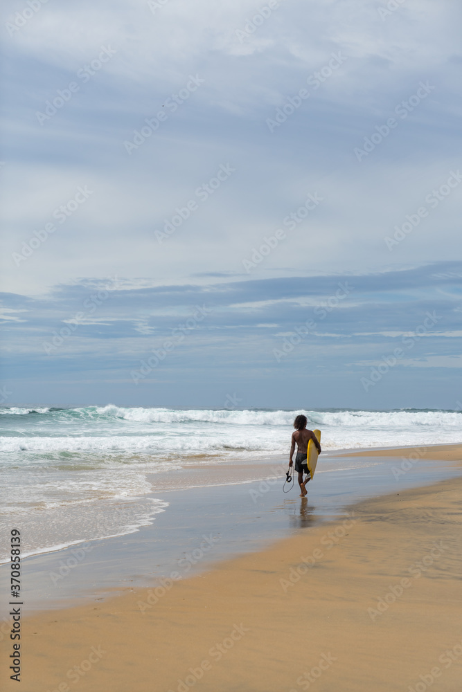 surfer on the beach, sunny day and cloudy sky, Arugam Bay, Sri Lanka surfer on the beach, sunny day and cloudy sky, Arugam Bay, Sri Lanka