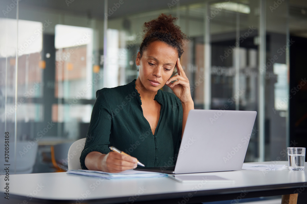 Portrait of pensive businesswoman working at desk Portrait of pensive businesswoman working at desk