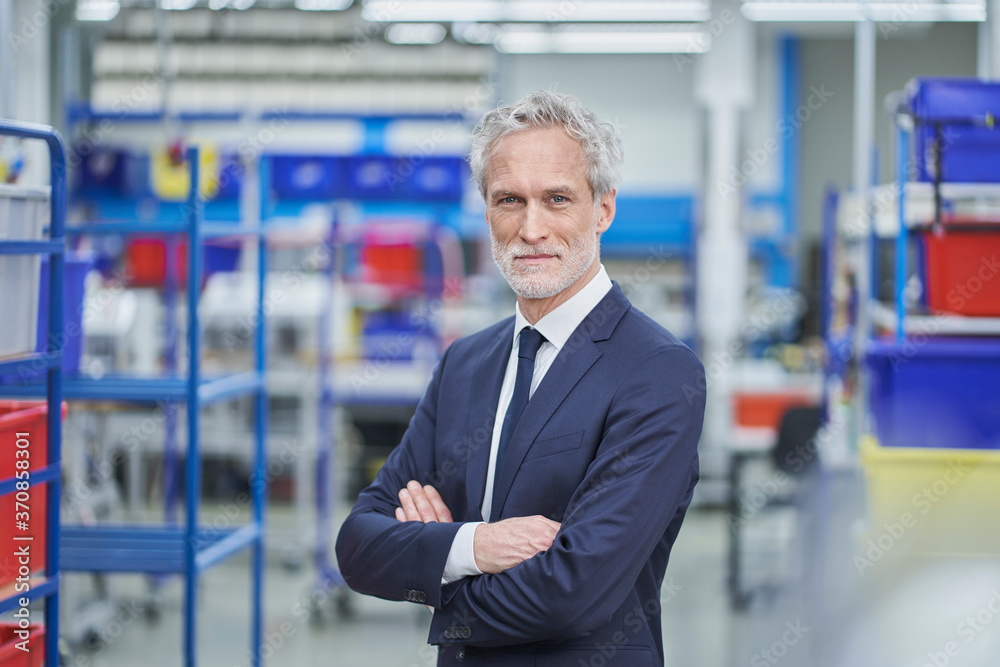 Confident male manager standing arms crossed in factory Confident male manager standing arms crossed in factory