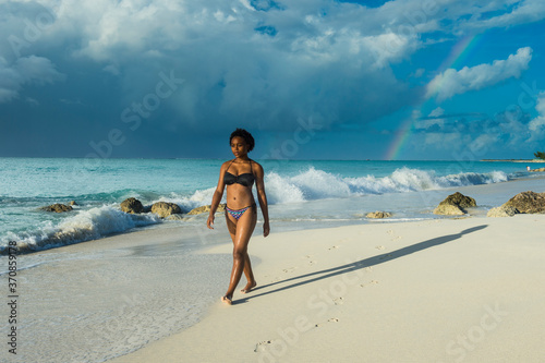Woman wearing bikini walking at Grace Bay beach against cloudy sky, Providenciales, Turks And Caicos Islands photo