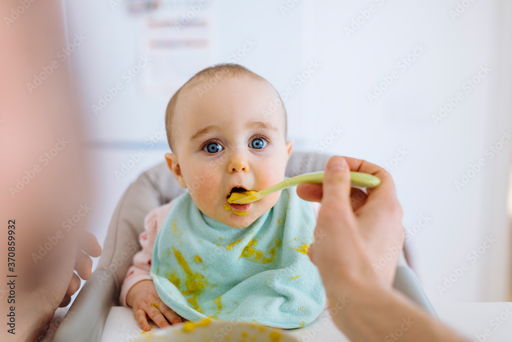 Father with baby in high hair at home Father with baby in high hair at home