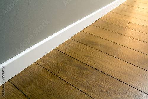 Obraz na płótnie Close up of white plastic plinths on dark wooden oak floor parquet