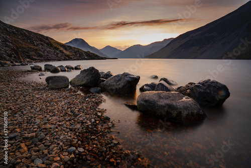Sunrise over Wast Water a lake located in Wasdale, a valley in the western part of the Lake District National Park, England. The lake is almost 3 miles long and more than one-third mile wide. It is a glacial lake, formed in a glacially 'over-deepened' valley. It is the deepest lake in England at 258 feet photo