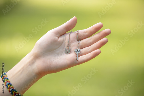 female hand holding a silver chain with key and heart  female decoration  valentine s day gift