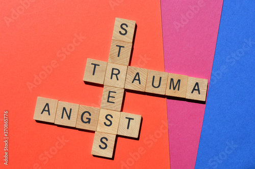 Stress, Trauma, Angst, words in wooden alphabet letters in crossword form on colourful background. photo