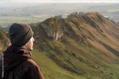Young man looking at the horizon at he top of a mountain view
