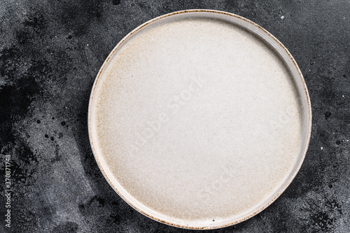 White empty round plate, restaurant background. Black background. Top view. Copy space.