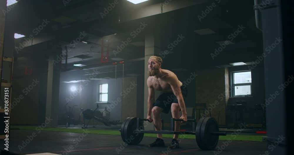 Athletic Beautiful man Does Deadlift with a Barbell in the Gym. Gorgeous male Professional Bodybuilder Workout Weight Lift Exercises in the Authentic Fit Training Facility. Athletic Beautiful man Does Deadlift with a Barbell in the Gym. Gorgeous male Professional Bodybuilder Workout Weight Lift Exercises in the Authentic Fit Training Facility.