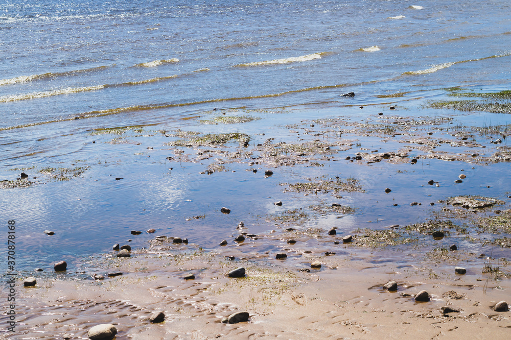 Stones on wavy wet sand. pebbles on the seashore. abstract background Stones on wavy wet sand. pebbles on the seashore. abstract background