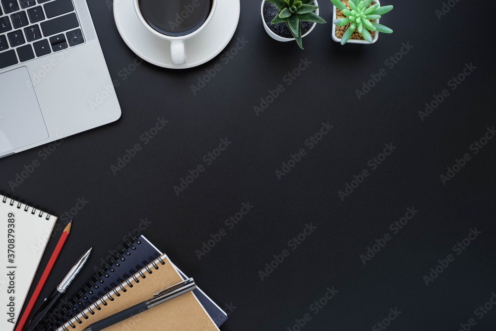 Top view above of Black office desk table with keyboard of laptop and notebook with equipment other office supplies. Top view above of Black office desk table with keyboard of laptop and notebook with equipment other office supplies.
