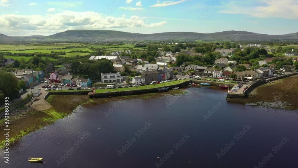 Kinvara, Galway, Ireland, August 2020, Drone pulling backwards away from fishing village and out over water. Kinvara, Galway, Ireland, August 2020, Drone pulling backwards away from fishing village and out over water.