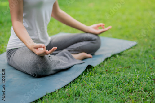 Healthy women doing yoga in the moring at the park . concept healthy and outdoor activity.