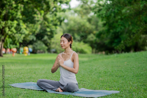 Healthy women doing yoga in the moring at the park . concept healthy and outdoor activity.