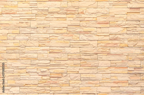 background and texture of yellow decorative stone wall surface.
